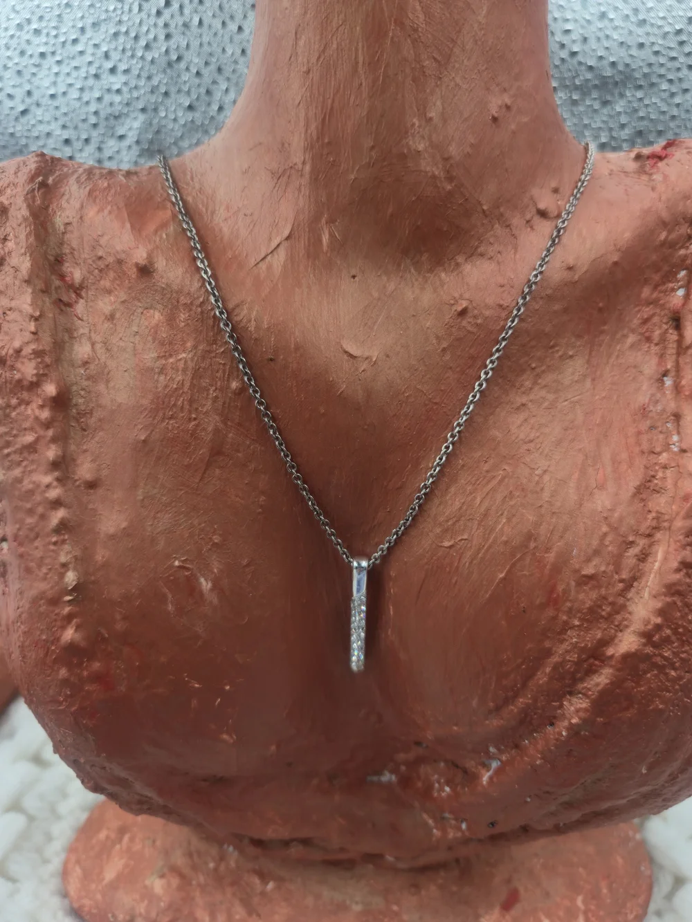 Nine West necklace features a dainty bar pendant adorned with pavé stones